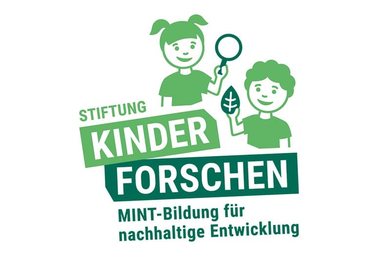 Kinder beim gemeinsamen Forschen mit Lupe und Wasser