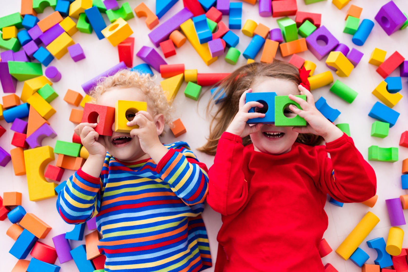 Helles Gruppenzimmer der Kita StarKids mit großen Fenstern und runden Spieltischen
